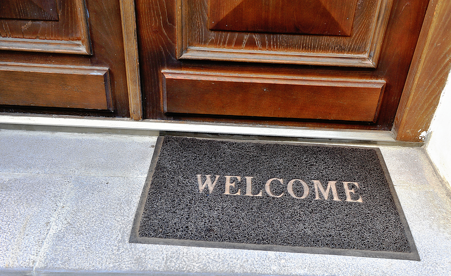 door mat cleaning service - Doormat-With-Welcome-Sign-At-The-Entrance-Of-A-House